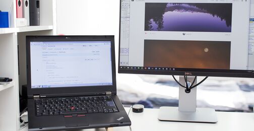 Laptop und Monitor an einem hellen Arbeitsplatz
