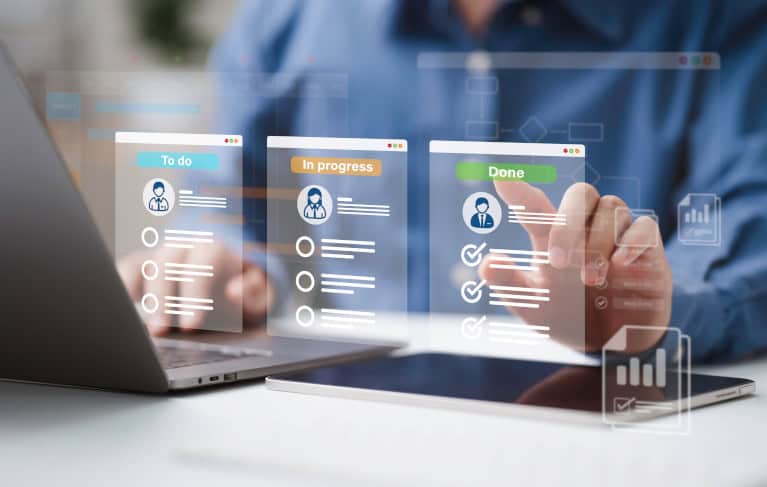 Mann mit Notebook und Tablet tippt auf ein Hologramm